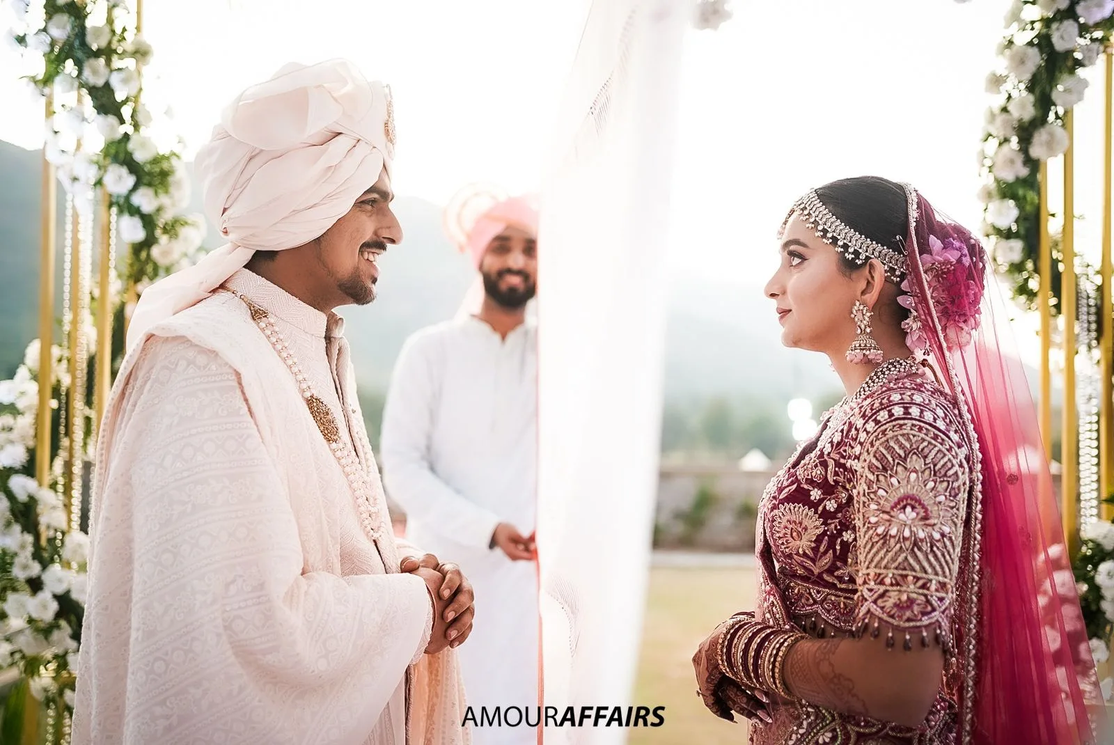 Candid wedding photography in Pune by Amour Affairs: the groom smiling as he sees his bride at the mandap